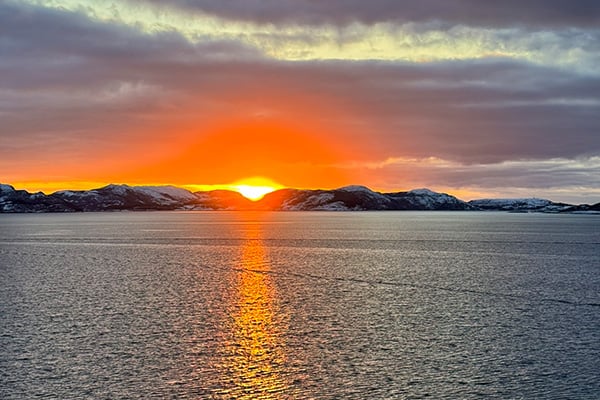 Sunset view from the top deck of MS Trollfjord sailing away from Bronnoysund, Norway