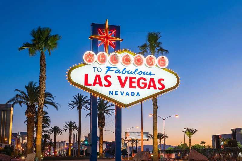 a sign in the evening welcoming visitors to las vegas.