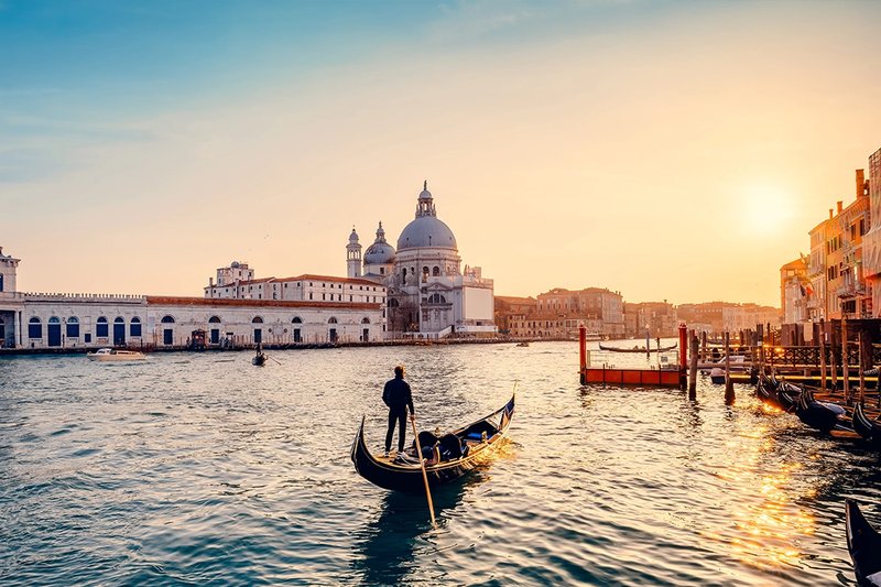 man rowing a gondola in venice.